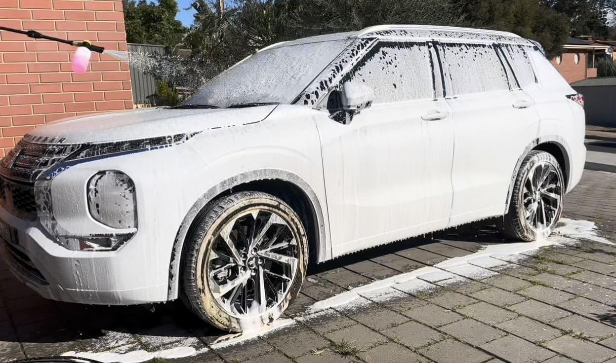 Mitsubishi Outlander covered in snow foam during an exterior wash