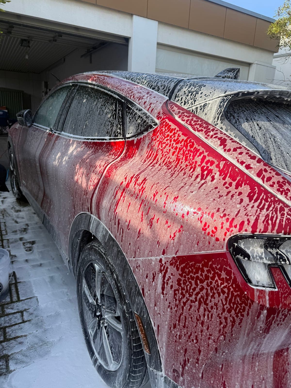 Snow foam covering a red Mustang Mach-E